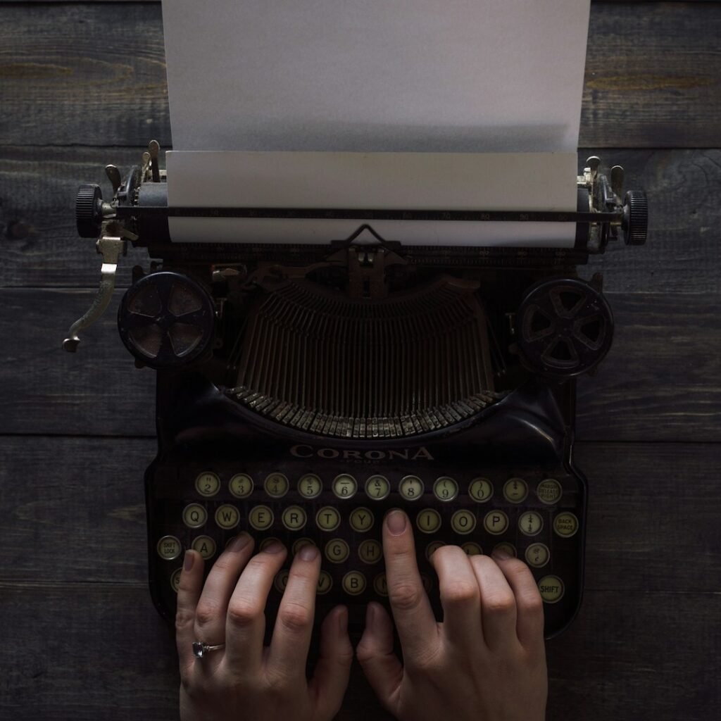 person holding white and black typewriter